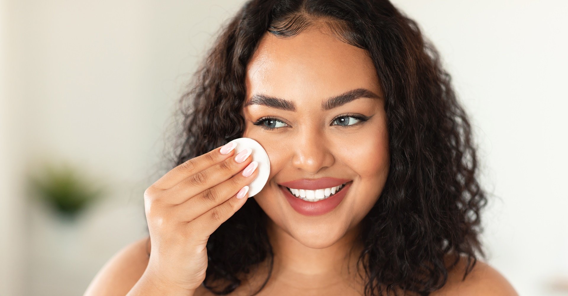 Mulher utiliza demaquilante bifásico para remover a maquiagem do rosto